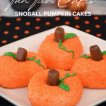 Four SnoBall Pumpkin Cakes on a white plate sitting on a black and orange polka dot background