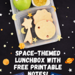 A space-themed lunchbox filled with mini sandwiches shaped like a shooting star, sun, and moon, an alien apple, candy rock asteroids, and star, sun and moon-shaped cheese bites.