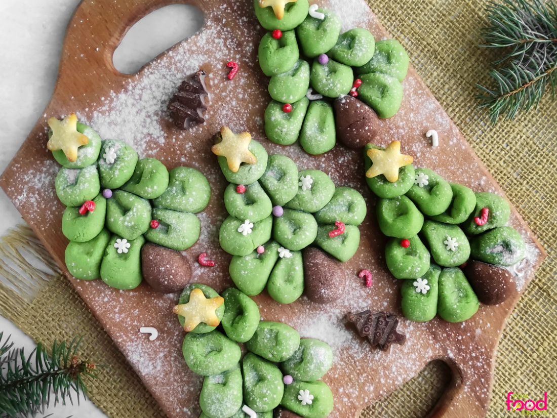 Pull Apart Christmas Tree Sugar Cookies Five green pull apart Christmas tree cookies built from dough balls with brown trunks, gold stars and sprinkles on a board