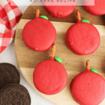 close up image of finished Apple Oreos on a wooden cutting board with pretzel sticks and green M&Ms around the board