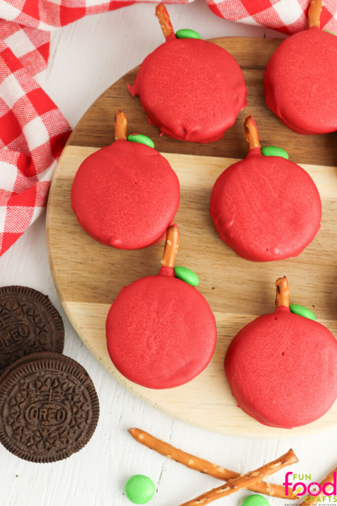 Apple Oreos on a cutting board sitting on a white background