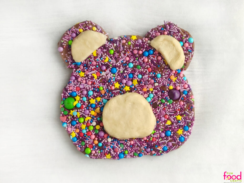 Adding white accents to bear-shaped cookie dough