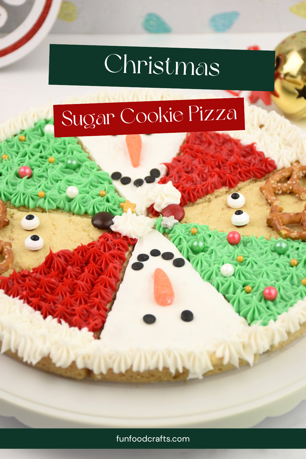 Christmas sugar cookie pizza decorated with Rudolph, Santa hat, Christmas tree, and snowman slices arranged in a colorful holiday design.