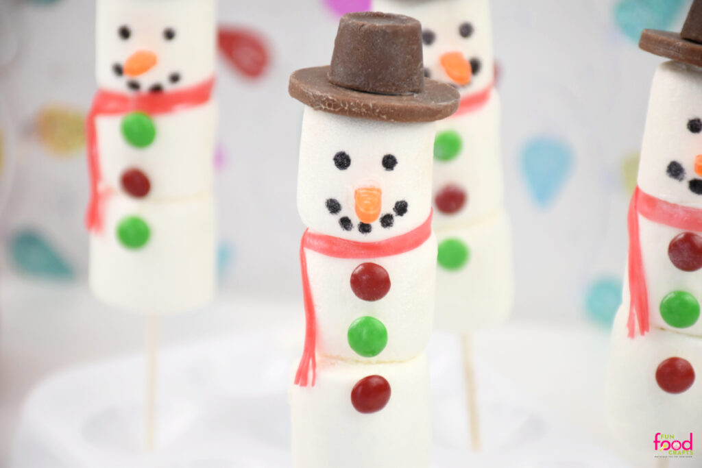 Close up of a snowman wearing and hat and scarf made of marshmallows