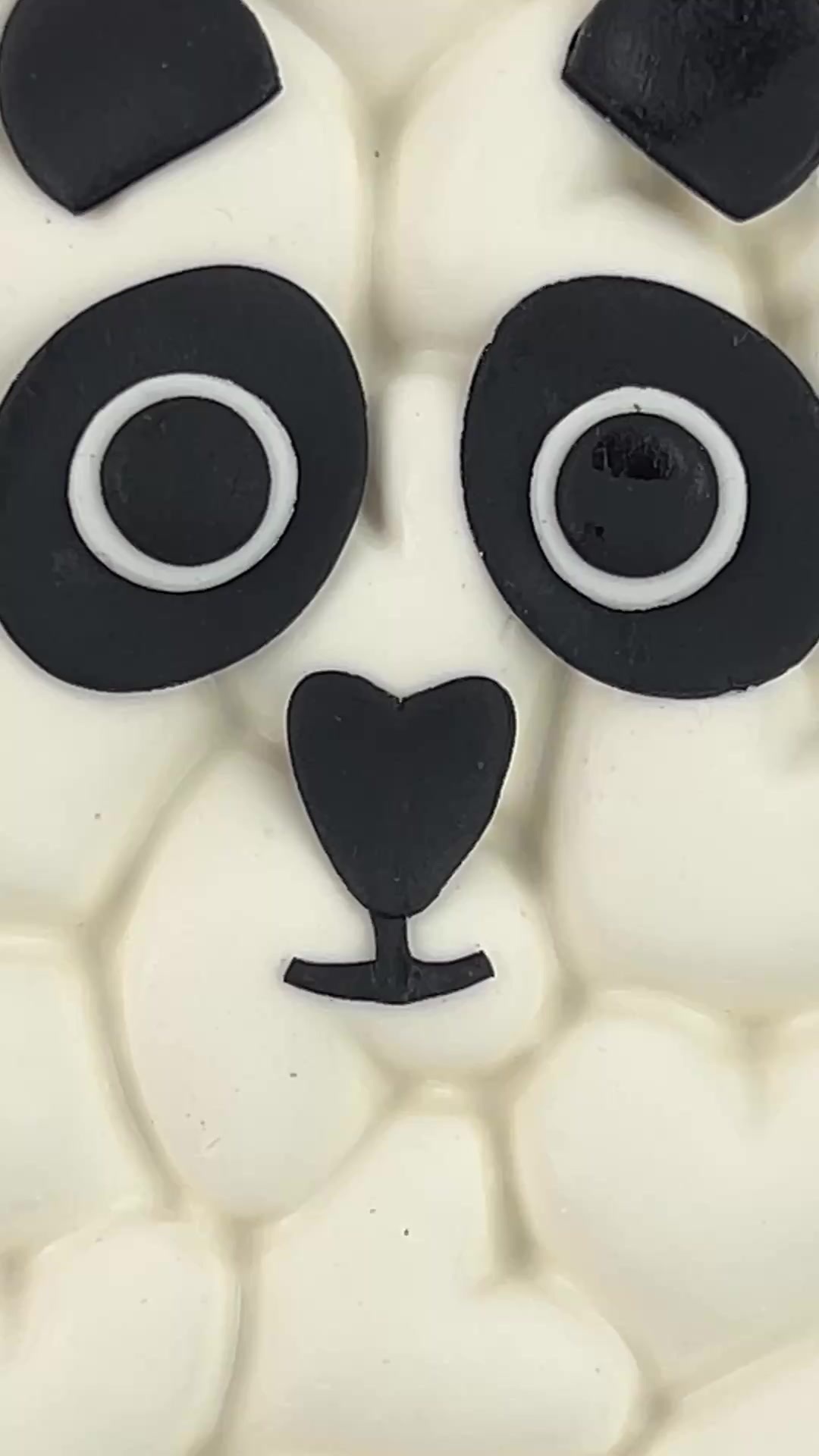 Cute panda candy bar with heart-textured white coating and large fondant eyes